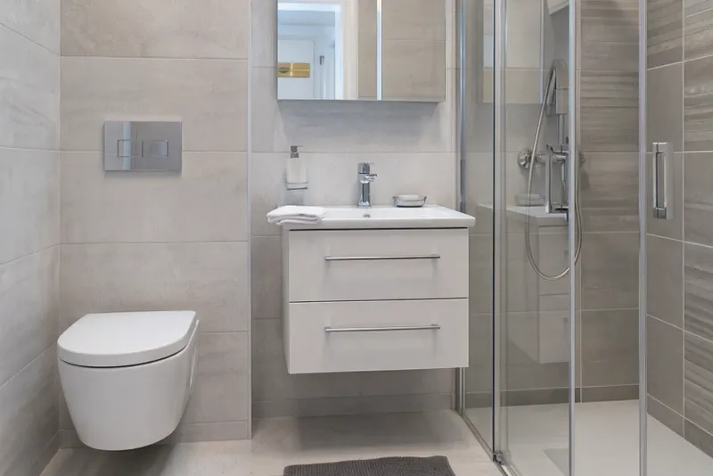 Salle de bain moderne rénovée par Raynier avec douche à l'italienne et WC suspendu